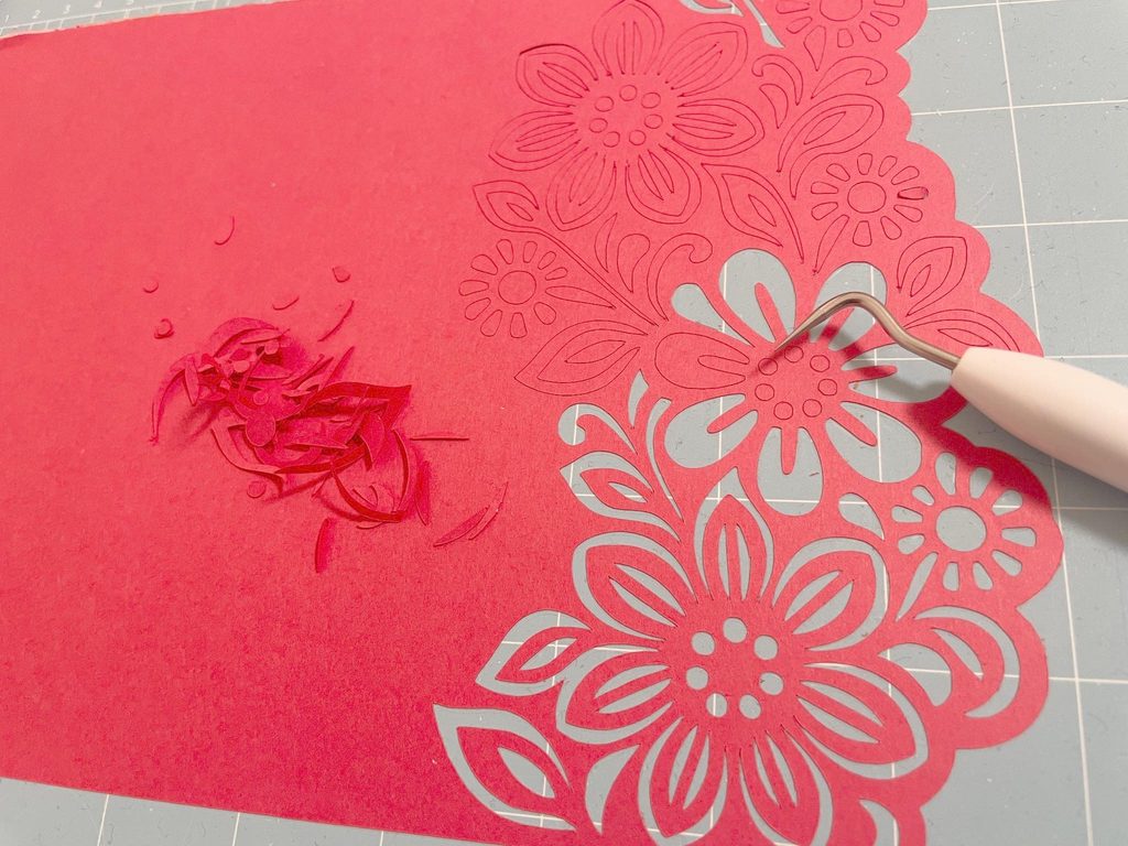 Cricutでカットした花柄から細かな紙をウィーダーで取り除いている画像